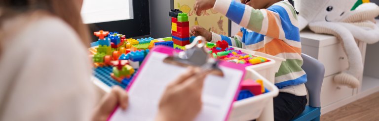 A picture of a child playing with blocks while being assessed.